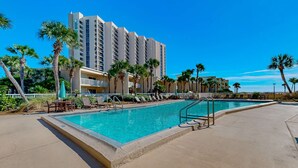 A swimming pool with lounge chairs and a building in the background. - 2nd-floor condo with beach access, pool, tennis courts, & on-site laundry (Destin)