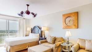 Ein Hotelzimmer mit einem großen Bett, einer Couch, einem kleinen Tisch und einer Wanduhr.