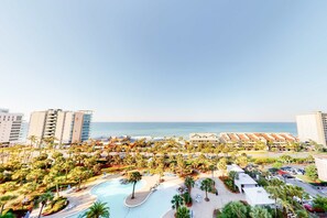 Ein Resort mit Schwimmbad, Palmen und Blick auf den Strand.
