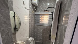 Ein kleines Badezimmer mit Toilette, Waschbecken und Dusche.