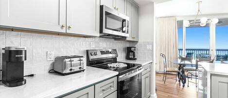 Una cocina moderna con microondas, tostadora, cafetera y horno.