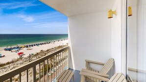 En balkon med udsigt over strand og hav.