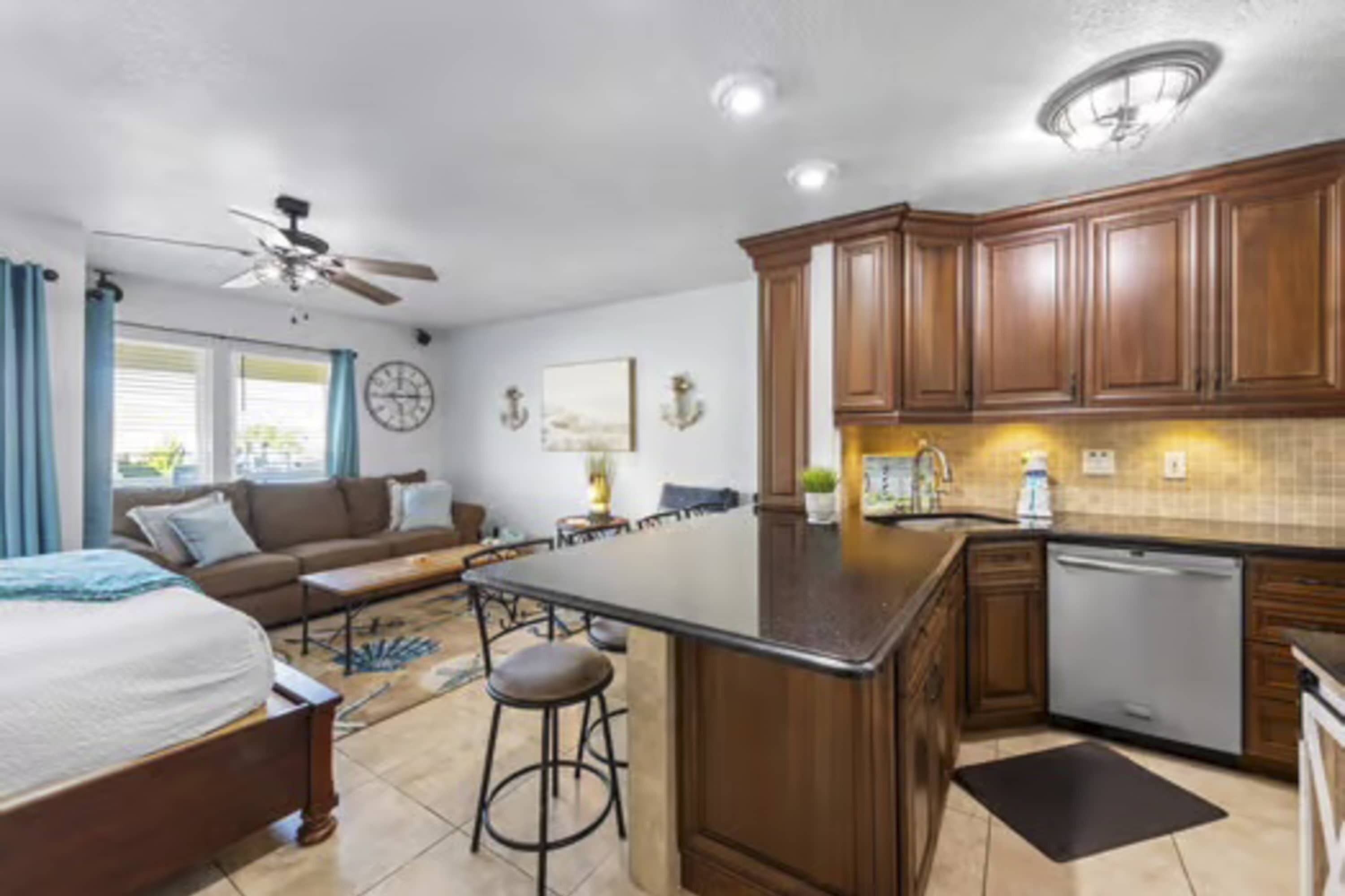 A modern kitchen with wooden cabinets, a central island, and a dishwasher.