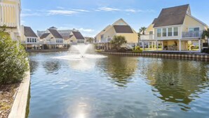 Un canal bordé de maisons d’un côté et surmonté d’une fontaine au centre.