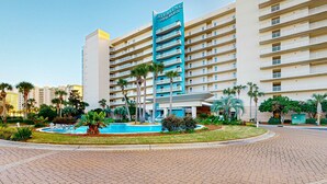 Un hotel con una piscina central, varios balcones y un llamativo letrero de 'Sterling Shores'.