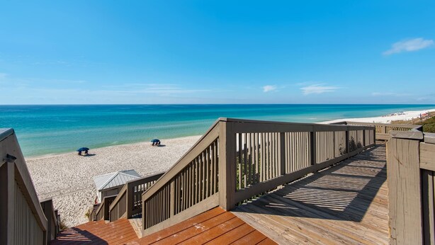 A wooden boardwalk leading to a beach with clear blue water and a sandy shore. - Spacious getaway with Gulf view, beach access, tennis & pickleball (Seacrest)