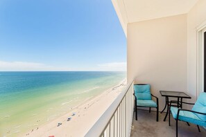 Un balcon avec vue sur une plage et l’océan.