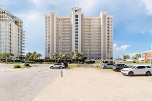 A large hotel with multiple floors, a prominent 'W' logo, and a parking lot with several cars.