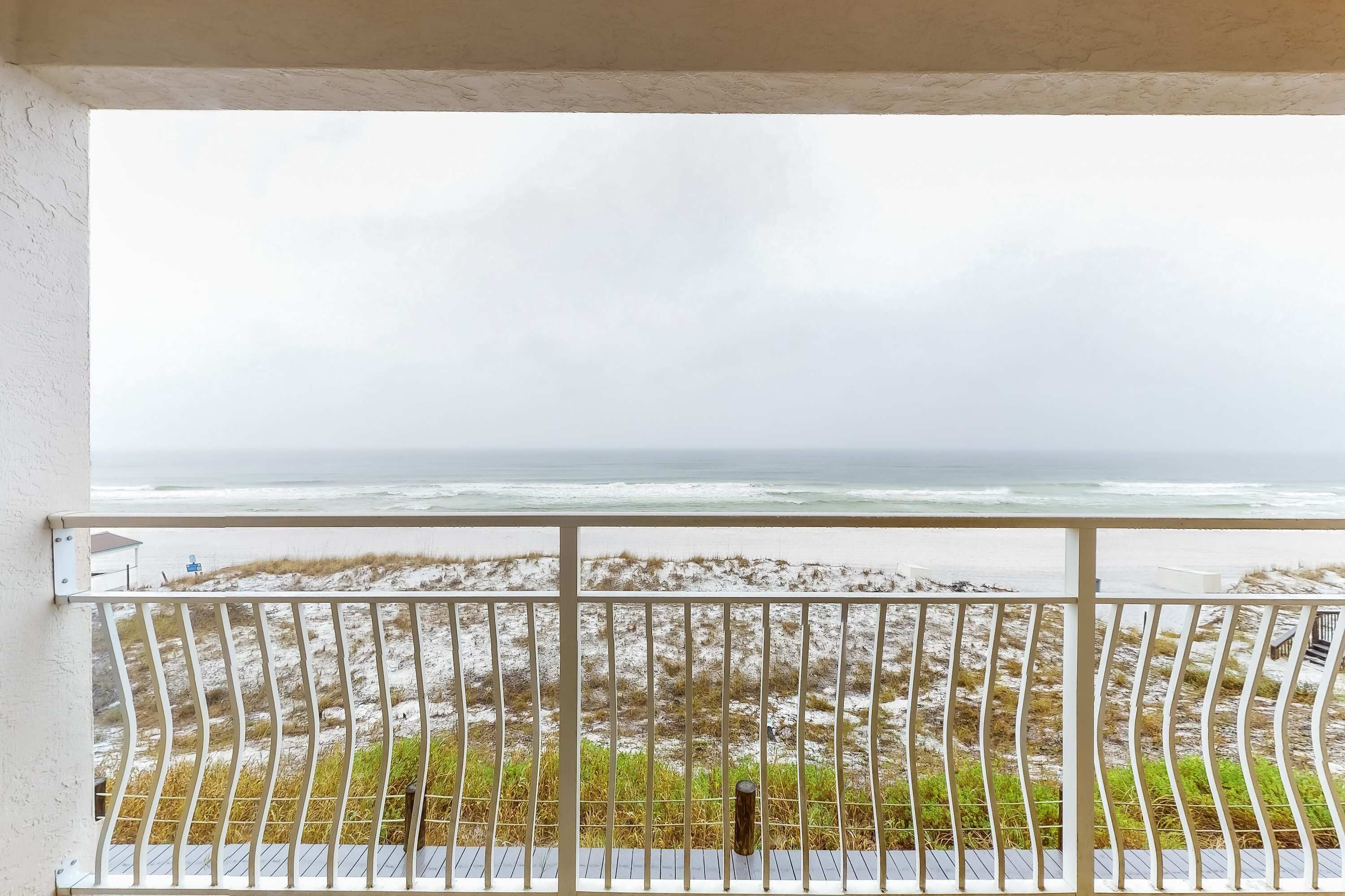 Un balcon avec vue sur la plage et l’océan.