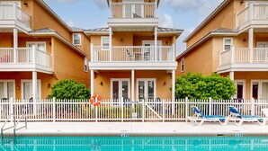 A two-story hotel with balconies, a swimming pool, and a white fence. - Ideal Coastal Retreat w/ Shared Pool, Private Balcony, & Beach Access Nearby (Panama City Beach)