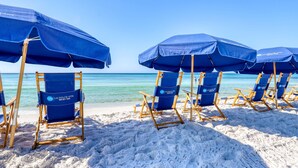 Beach chairs and umbrellas arranged on a sandy beach with a clear view of the ocean. - Majestic Sun B1011 | Beachfront Condo with Pool! (Miramar Beach)