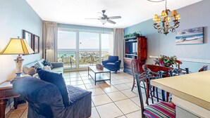 Ein geräumiges Wohnzimmer mit Balkon, Essbereich und Fernseher.