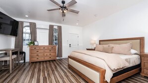 A bedroom with a bed, wooden dresser, desk, and a ceiling fan. - Exquisite Chic King Suite at Yosemite`s Doorstep (Oakhurst)