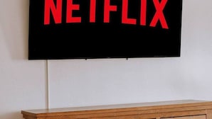 A flat-screen TV mounted on a wall with the word "NETFLIX" displayed in red letters. - Exquisite Chic King Suite at Yosemite`s Doorstep (Oakhurst)