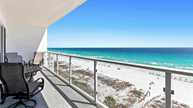 Ein Balkon mit Blick auf Strand und Meer.