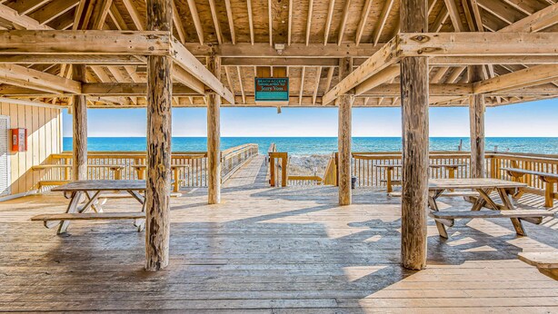 A wooden deck with picnic tables and a sign indicating beach access. - Sparkling Studio with Shared Pools, Hot Tubs, Golf, Tennis, & a Private Beach (Destin)