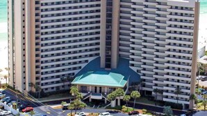 Un hotel moderno con numerosi balconi, un cortile interno e un’area di parcheggio.