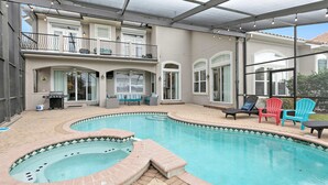Ein Swimmingpool mit Whirlpool, Liegestühlen und einer überdachten Terrasse.