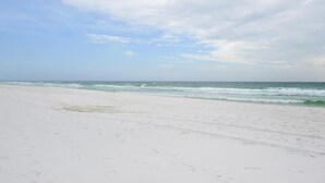 Ein Strand mit weißem Sand und Meereswellen.