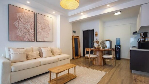 Un salon moderne avec un canapé, une table basse et des œuvres d’art accrochées au mur.