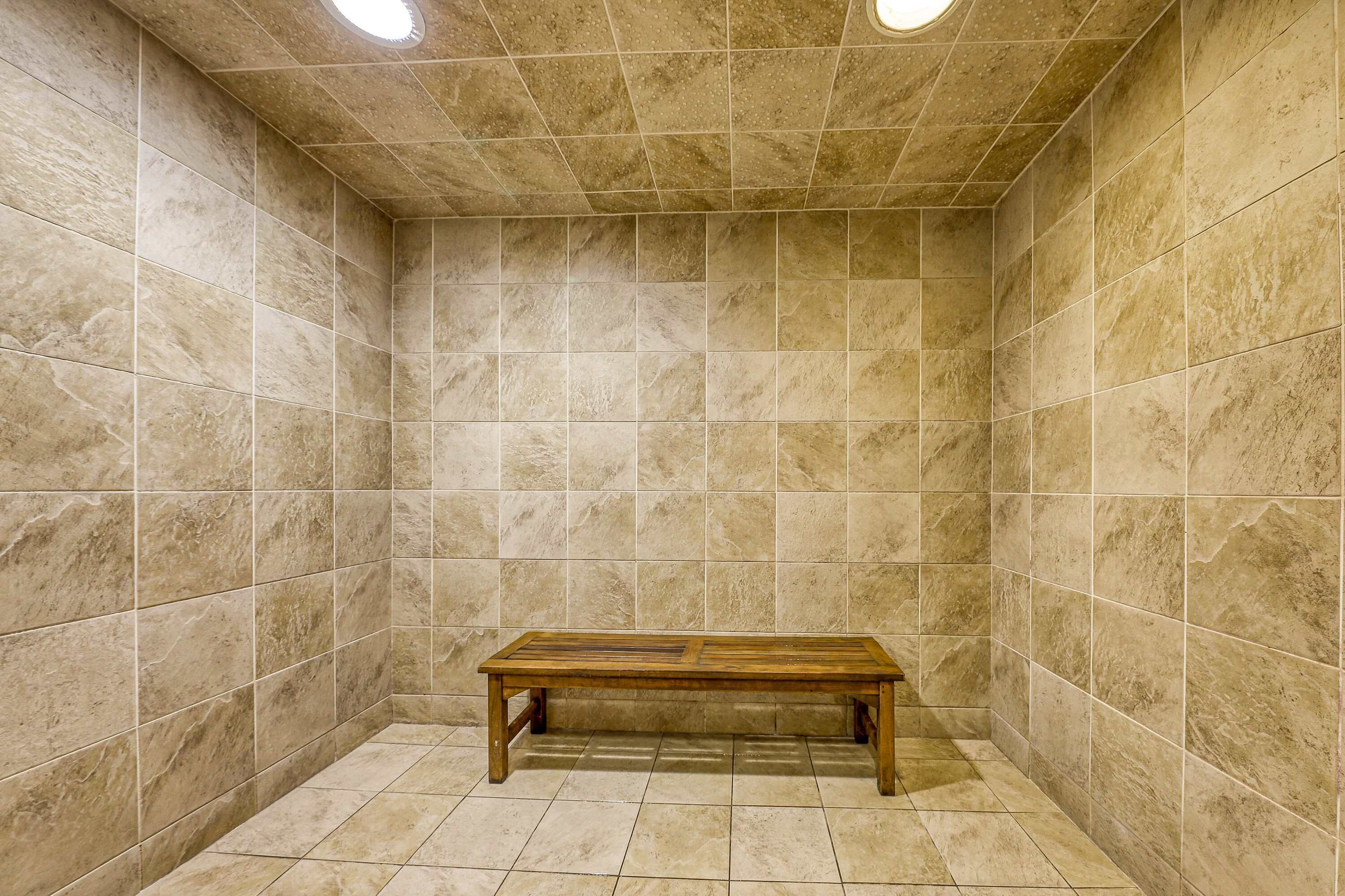 A small, tiled room with a bench in the center.