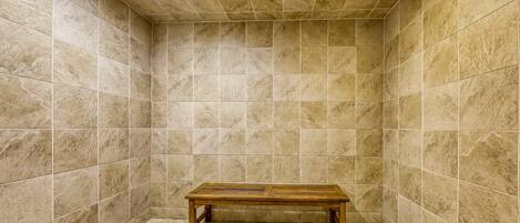 A small, tiled room with a bench in the center.