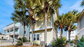 A multi-story building with balconies and palm trees. - Gorgeous, private, coastal home with a shared pool, fitness room (Santa Rosa Beach)