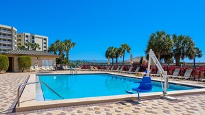 A swimming pool with lounge chairs and a lifeguard stand. - Colorful Gulf-view condo with pools, hot tub, tennis, gym & easy beach access (Destin)
