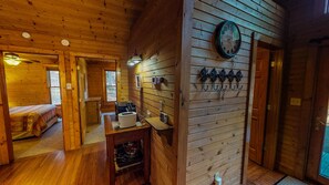 L’intérieur d’un chalet en bois comprend un lit, un coin cuisine et une horloge fixée au mur.