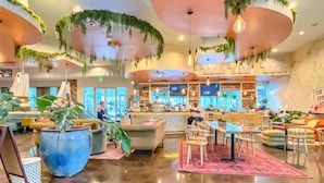 Un espace lounge moderne comprenant des sièges, un bar et des plantes décoratives.