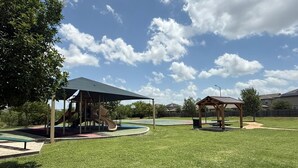 Un parque infantil con un tobogán y una zona de estar techada.