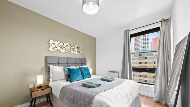 A modern bedroom with a grey headboard, white bedding, and a grey patterned throw. - One bed apt opp tube station central line (London)
