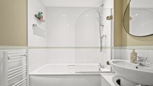 A modern bathroom with a bathtub, a shower, and a sink. - One bed apt opp tube station central line (London)