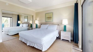 A hotel room with two beds, a large mirror, a painting on the wall, and a view of the outdoors. - Snowbird-friendly condo with beach views, private beach, heated pool (Destin)