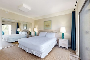 A hotel room with two beds, a large mirror, a painting on the wall, and a view of the outdoors. - Snowbird-friendly condo with beach views, private beach, heated pool (Destin)