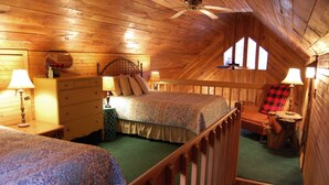 A cozy attic bedroom with two beds, wooden walls, and a sloped ceiling. - Creeksong-Harvest Moon (Logan)