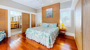 A spacious bedroom with a large bed, wooden wardrobe, and a ceiling fan. - Beautiful, dog-friendly cottage with deck & patio - stroll to Carrabelle Beach (Carrabelle)