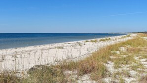 Une plage avec un ciel dégagé et une mer calme.