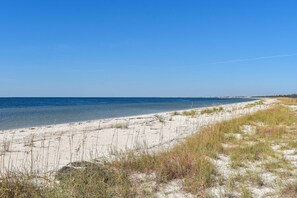 Ein Strand mit blauem Himmel und ruhigem Wasser.