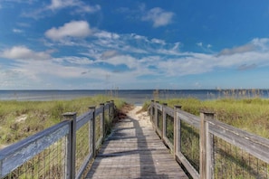 A wooden boardwalk leading to a beach with a clear sky. - Spacious coastal home with grill & screened porch (Port St. Joe)