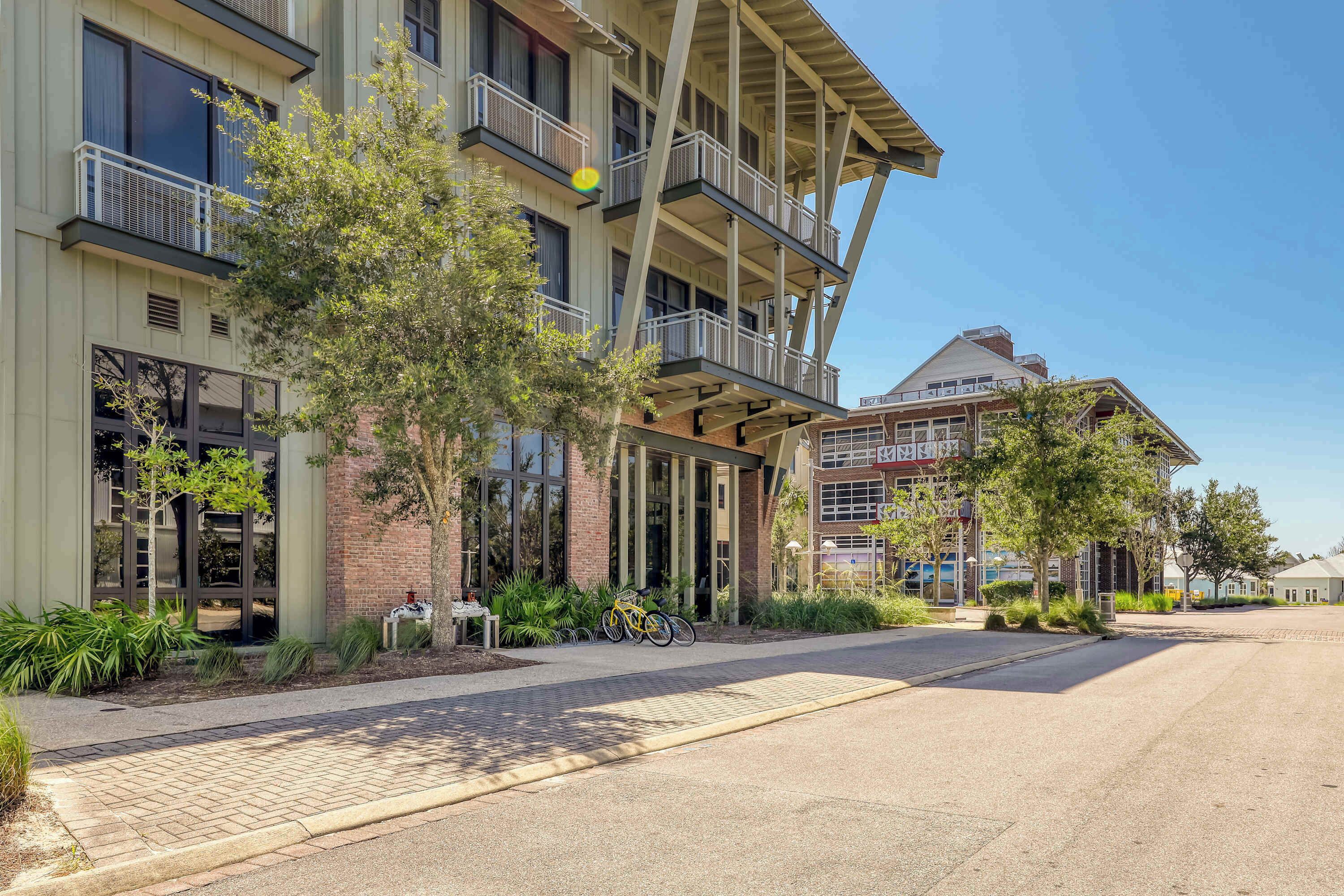 A multi-story building with balconies, a bike parked outside, and a clear sky.