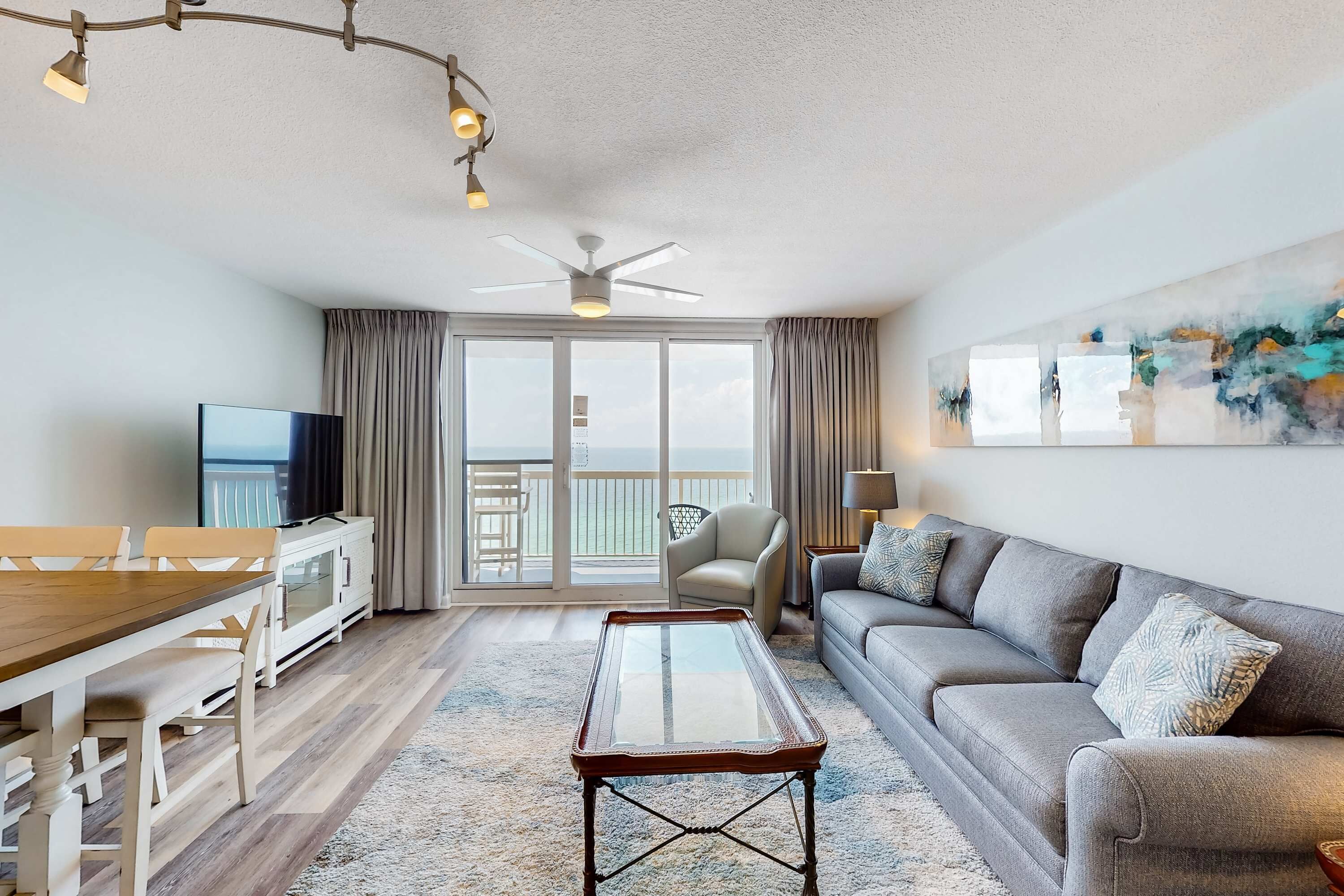 Un salon moderne comprenant un coin repas, un canapé, un téléviseur et un balcon avec vue.