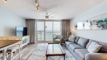 Un salon moderne comprenant un coin repas, un canapé, un téléviseur et un balcon avec vue.