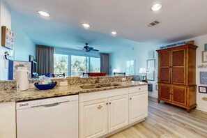 A kitchen with a granite countertop, white cabinets, and a wooden cabinet. - Marvelous Gulf-front condo with amazing views, pool, snack bar, & fitness room (Destin)