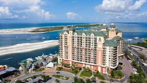 A high-rise hotel with multiple balconies, a beach view, and a marina. - Gulf-view condo with beach access, pool, hot tub, sauna, & private balcony (Destin)