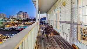 Ein Balkon mit Blick auf eine Stadtlandschaft, ein Poolbereich mit Booten und Sitzmöglichkeiten im Freien.