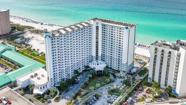 Ein Hochhaus-Hotel mit Innenhof, umgeben von Strand und Meer.