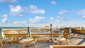 Eine Strandterrasse mit Sitzgelegenheiten und Blick auf den Strand.