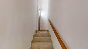 A staircase with a wooden handrail and a white wall. - Sunlit Marbella Apartment Near Sea (Marbella)