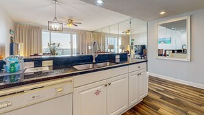 Een moderne keuken met een groot eiland, roestvrijstalen apparatuur en een grote spiegel.